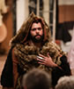 Production photo by Lindsey Walters of The Bear with silver claw talking to the audience